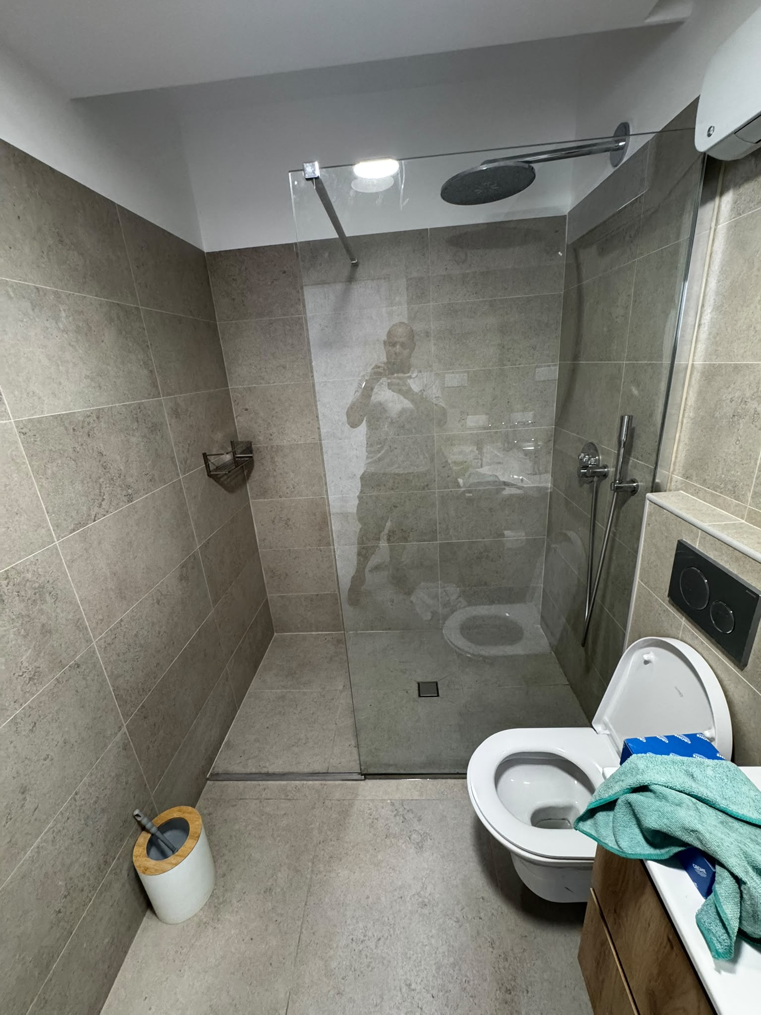 Shower drain repair completed with tiles and glass screen reinstated